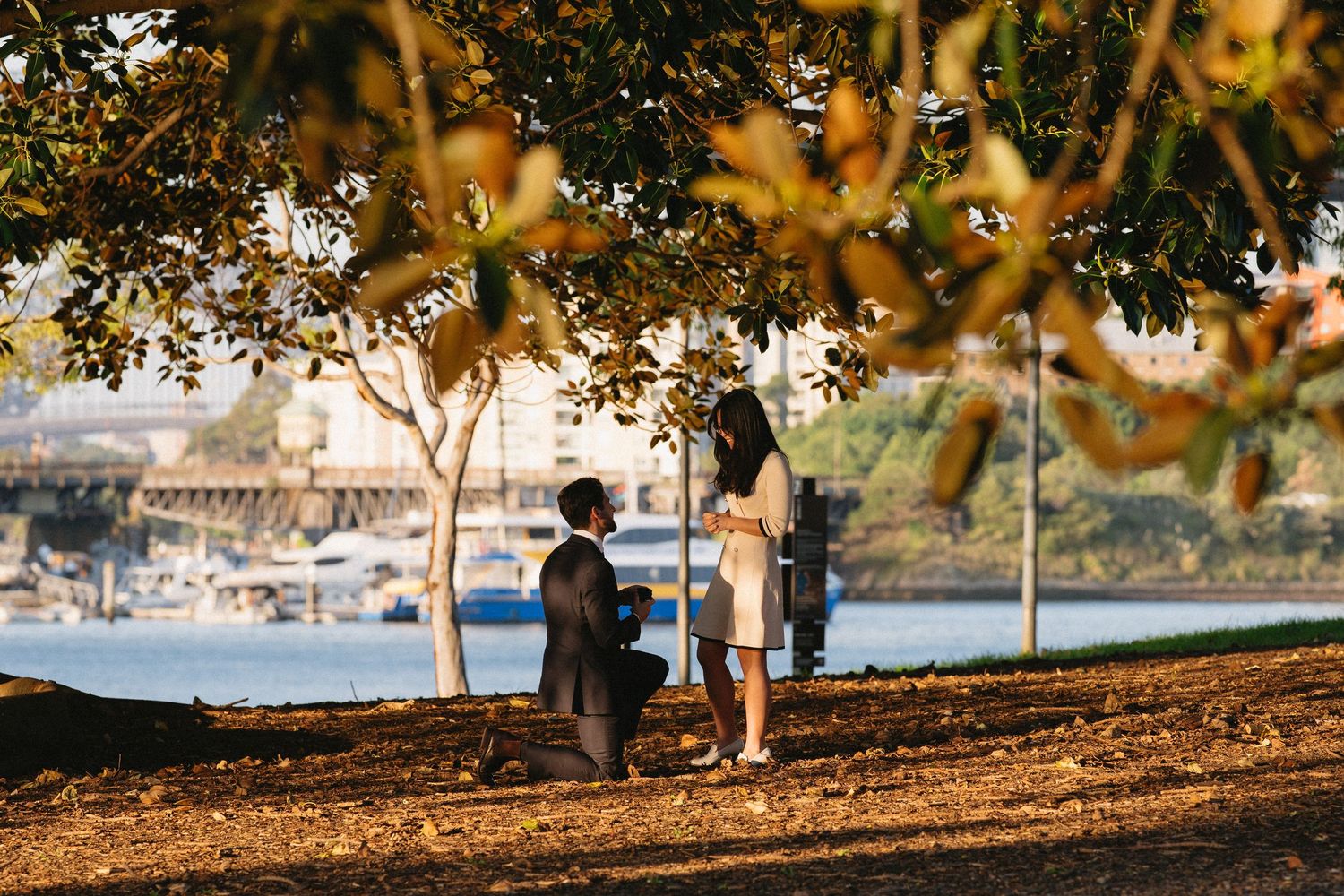 Couple shares a romantic sunset embrace in front of an elegant white gazebo.