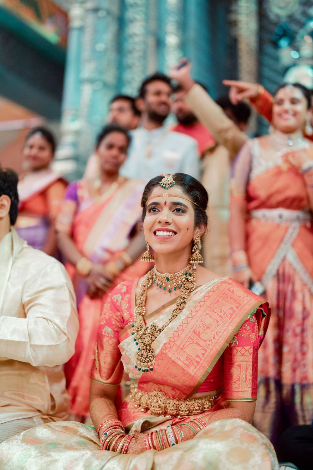 Candid moment during an Indian wedding ceremony with guests in colorful sarees.