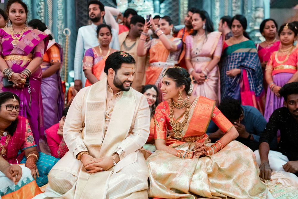 Wedding ceremony scene with guests in traditional Indian attire gathered around the couple.