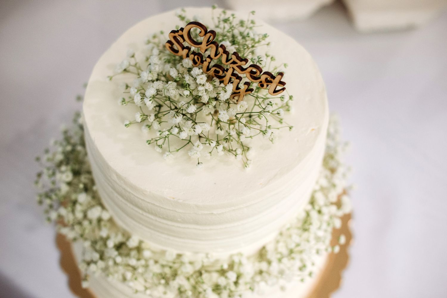 White frosted cupcake topped with delicate green sprinkles shown from multiple angles on a light surface.
