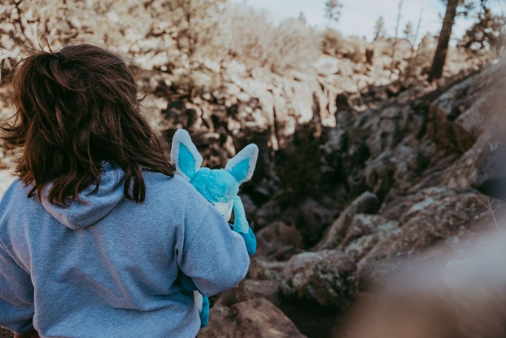 Young girl holds stuffed animal as she looks out over a canyon. Whitney Popp, Phoenix Arizona photographer.