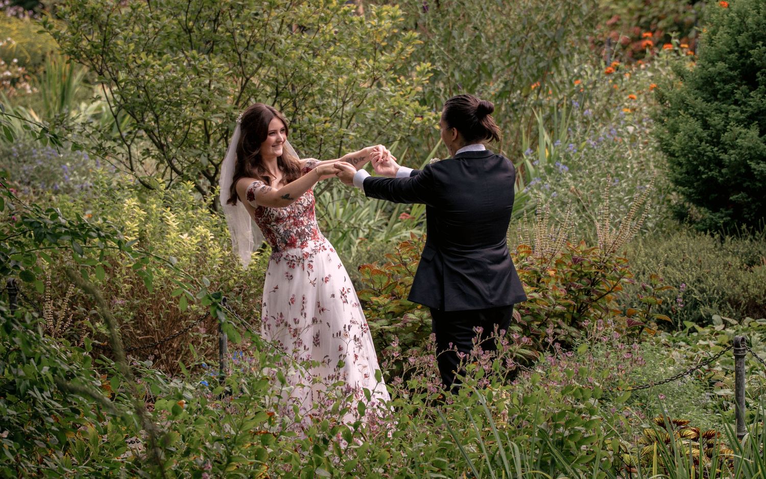Bride and groom dancing together in a vibrant garden during their wedding.