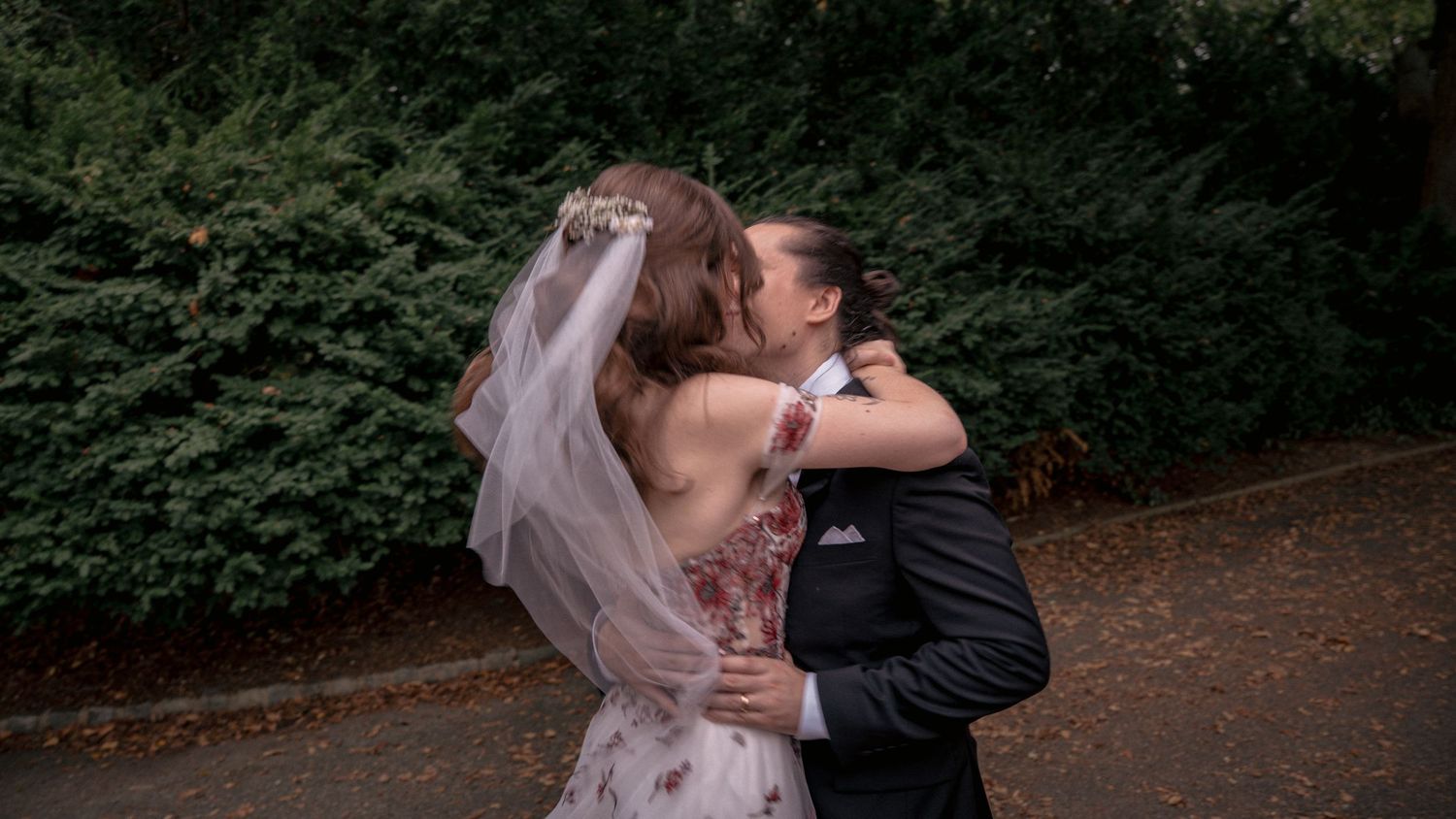 Bride and groom sharing a romantic embrace on their outdoor wedding day.