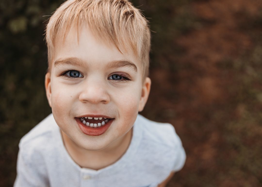 A series of close-up portrait photos showing joyful expressions and genuine smiles against a dark background.