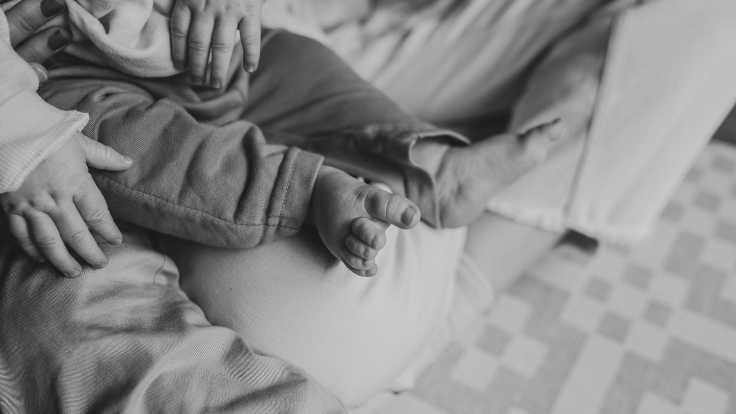 A black and white image shows hands