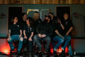 Group of bar staff in matching black T-shirts sitting together in Yelm WA bar during marketing session with pierce county photographer