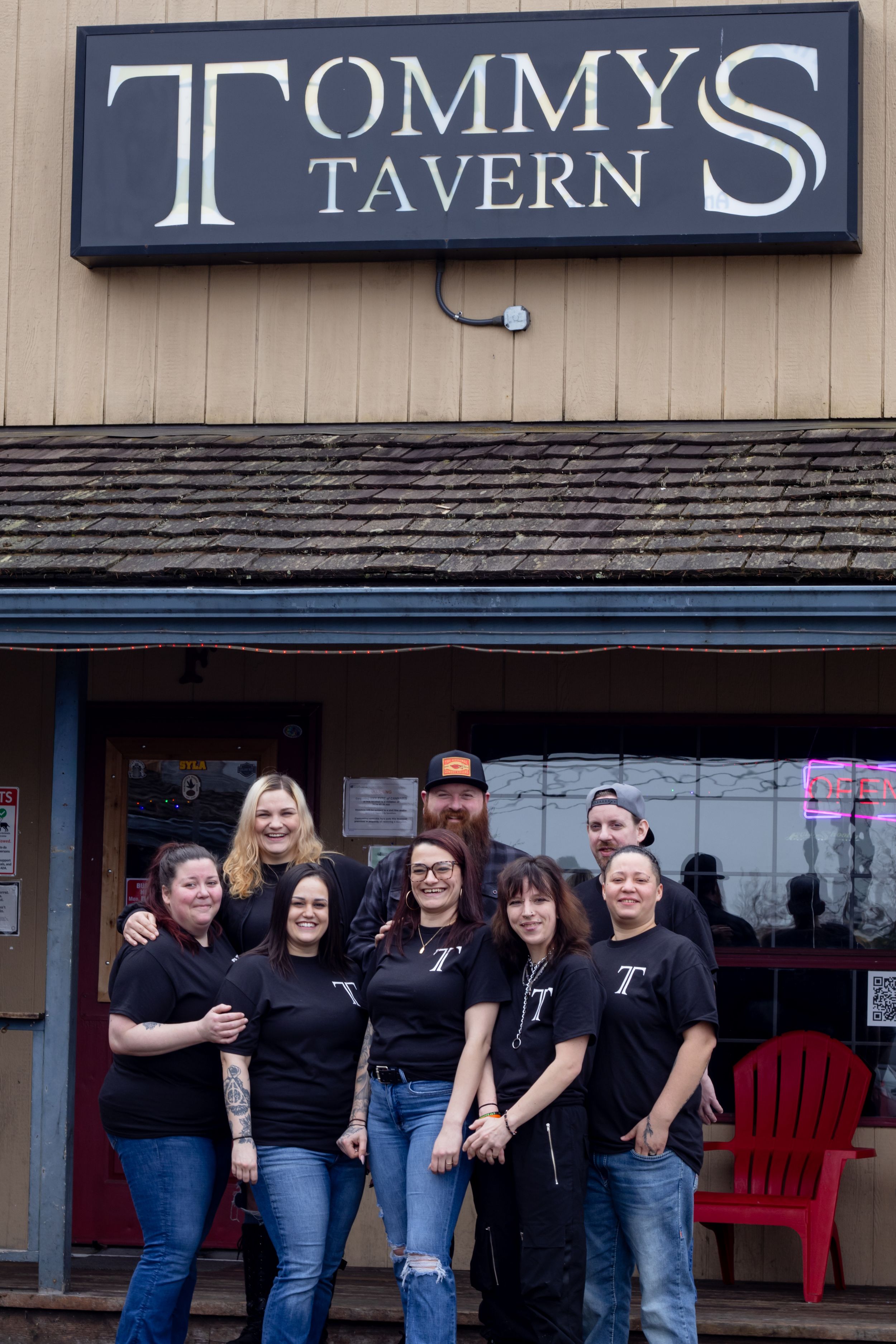 Tommy's Tavern staff posing in black uniforms outside the bar entrance during marketing photo session with pierce county photographer
