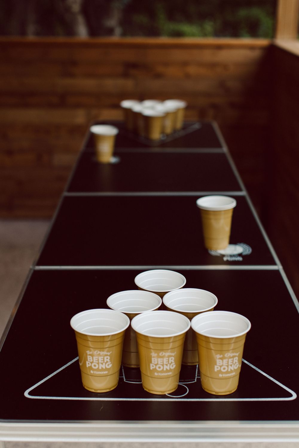 A sequence of four photos showing brown paper coffee cups arranged in rows on dark wooden surfaces.