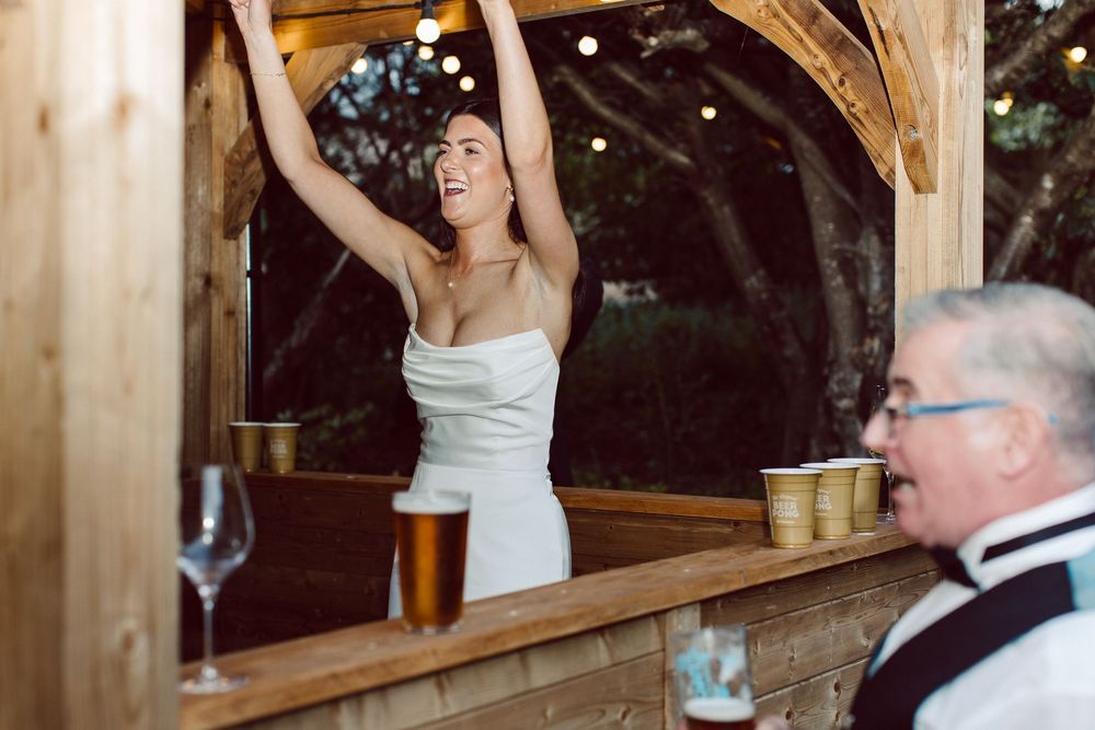 A wedding celebration at a rustic wooden venue with people dancing and enjoying the festivities.