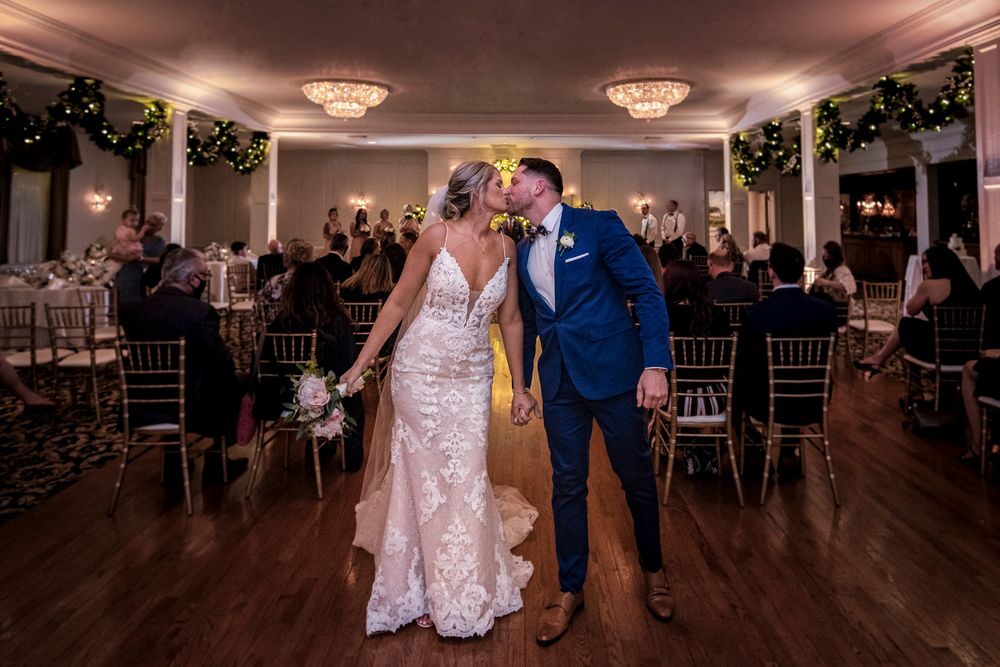 A wedding reception venue with elegant lighting and couples dancing on the dance floor.