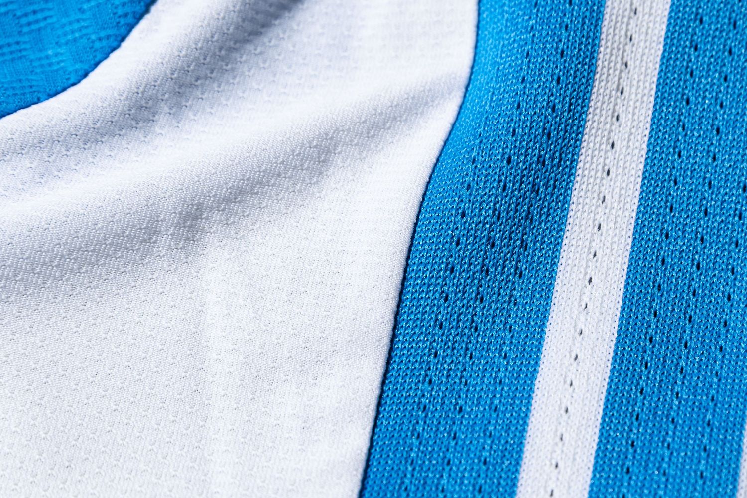 Detailed texture of blue and white Charlotte FC Adidas soccer jersey fabric.