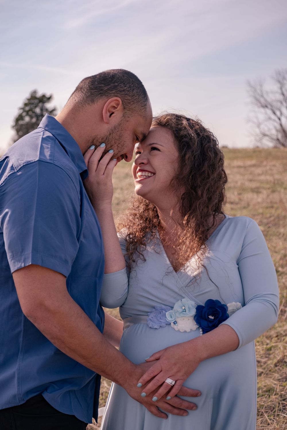 A couple shares an intimate moment together in an outdoor setting with soft overcast lighting.
