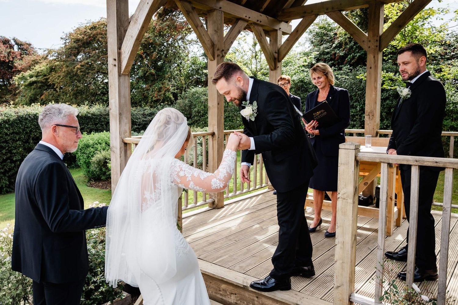 Groom helps bride into the gazebo at reach court farm