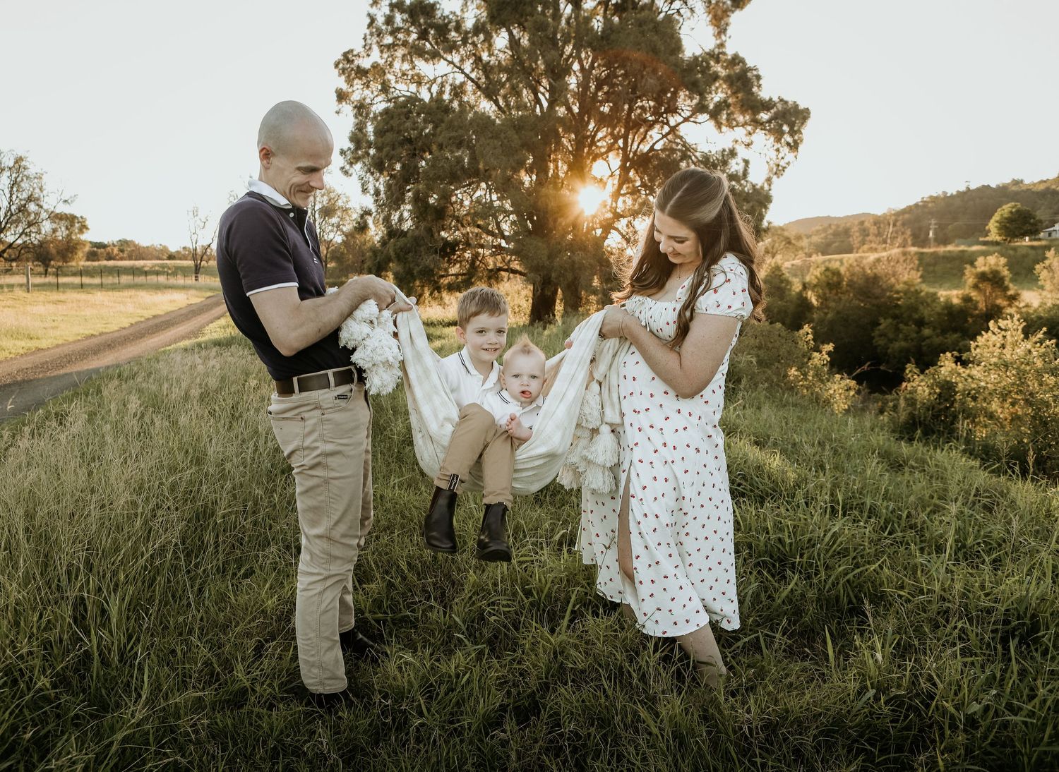 A couple walks together through a sunlit meadow at golden hour while holding hands and enjoying nature.
