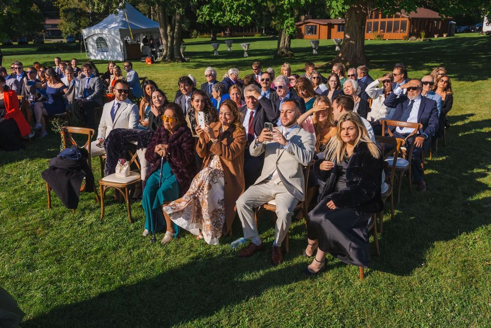 A large group of people gathered outdoors on a grassy lawn.
