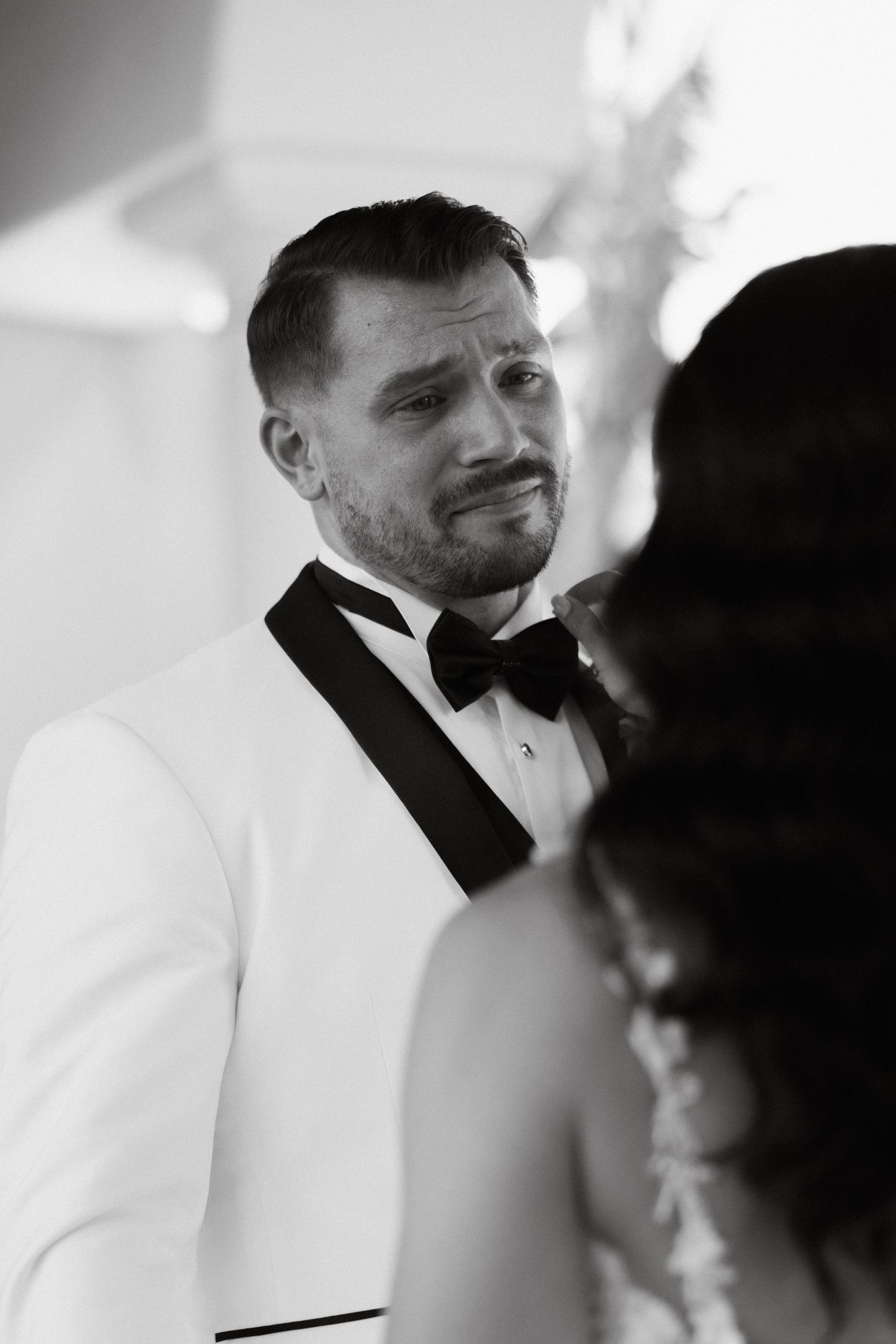 Black and white photo of groom reacting to his bride during their wedding at Spanish Hills in Camarillo, California
