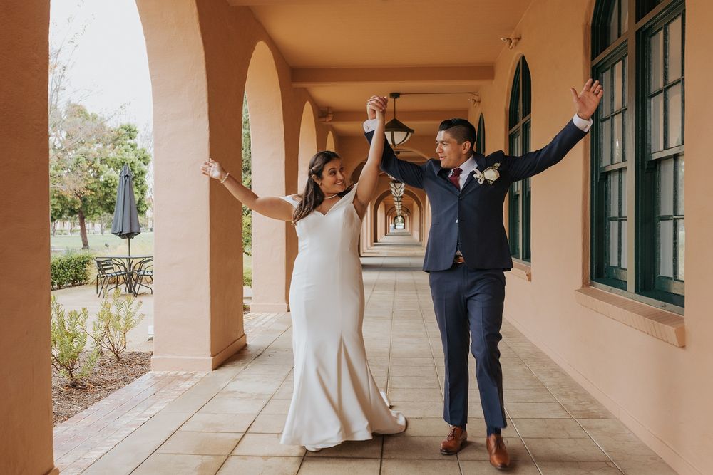 Couple walking together through the hallways of Liberty Station with arched columns and terracotta tiles.