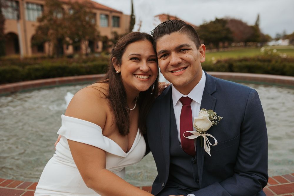Romantic couple shares intimate moments by a waterfront on their wedding day.