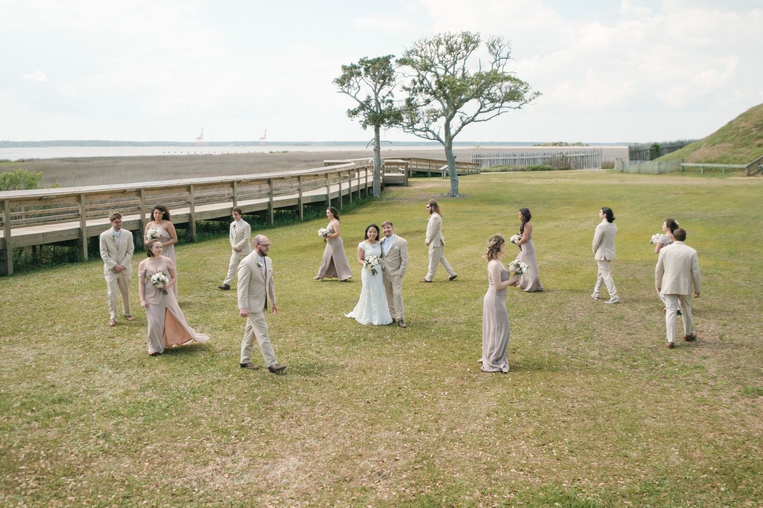 A group of people in white clothing gather on a grassy hillside for a special outdoor celebration.