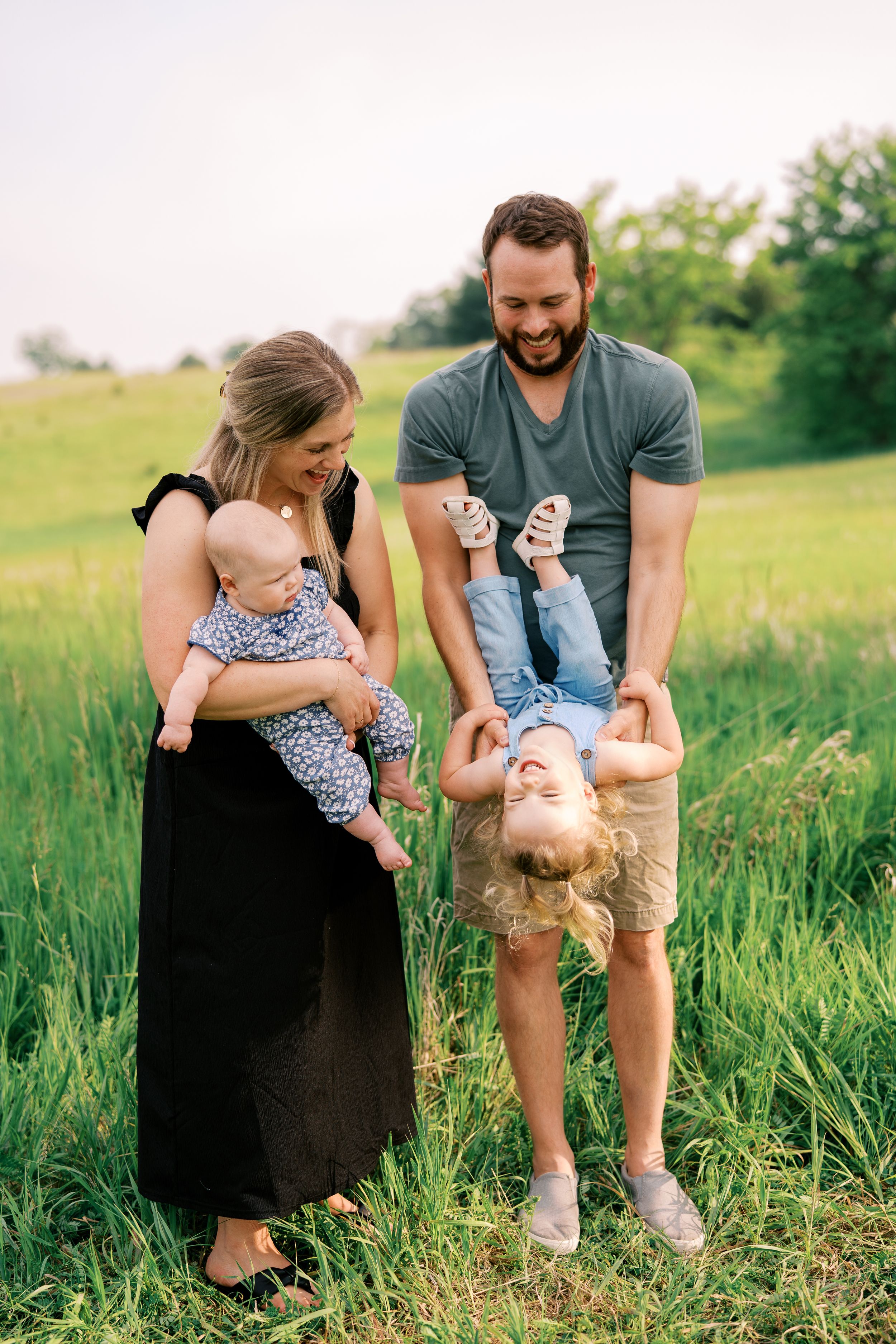 Candid family photos showing joyful interactions in tall grass during an outdoor session.
