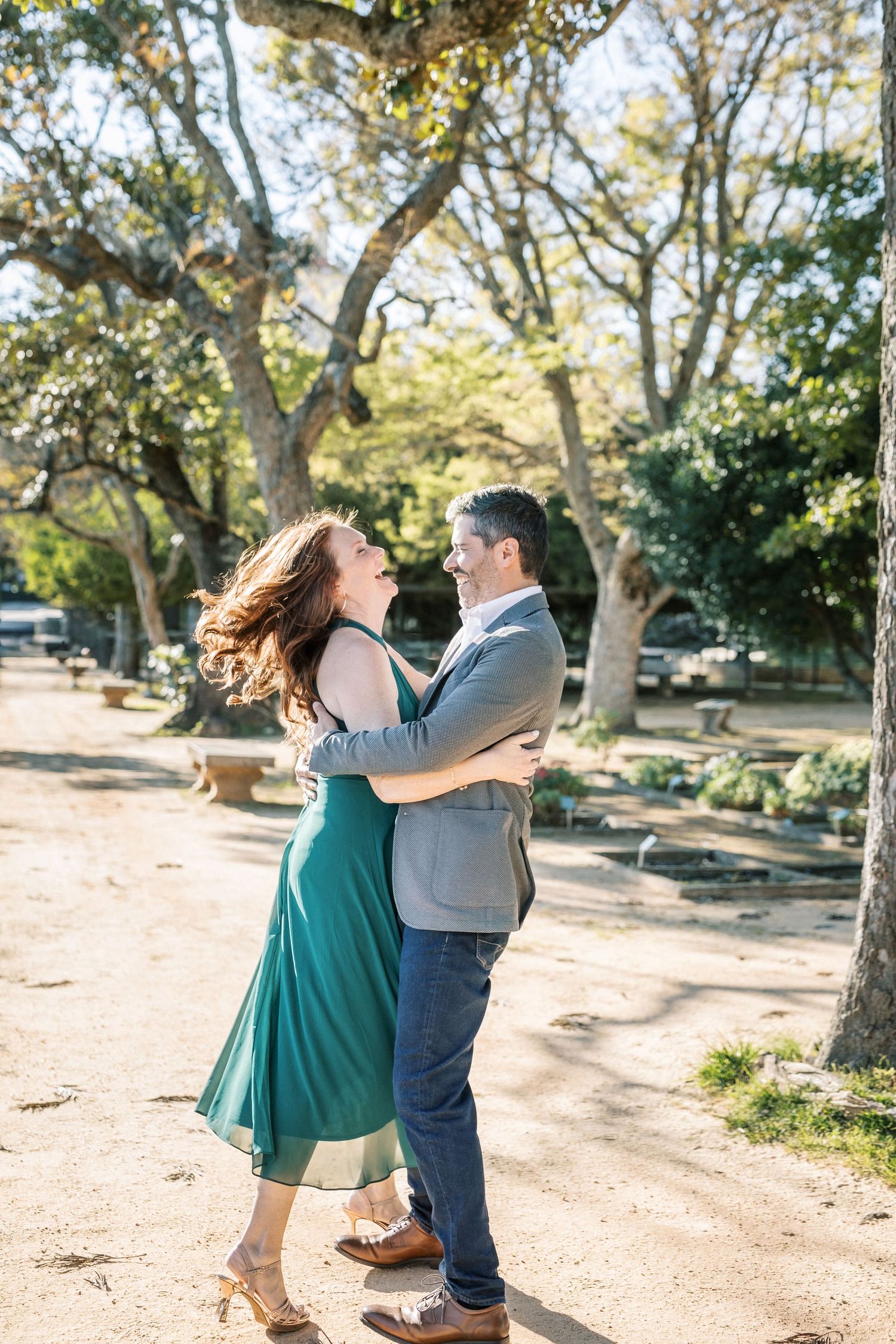 Couple laughing during engagement session in Lisbon garden