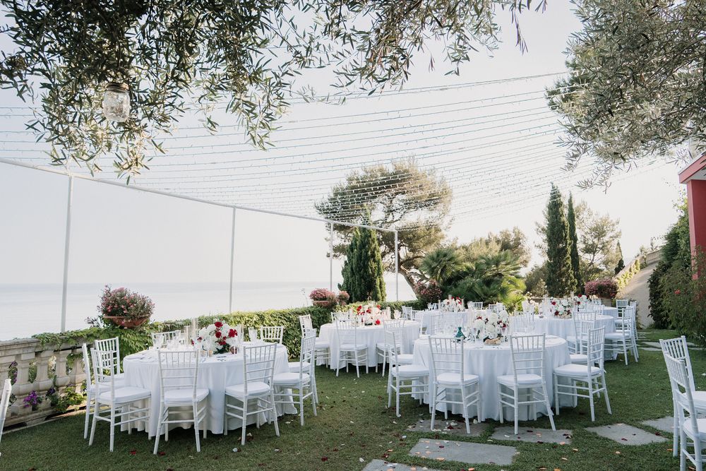 Wedding tables set up in the garden of Villa Casa Rossa in Imperia with a sea view in Liguria.