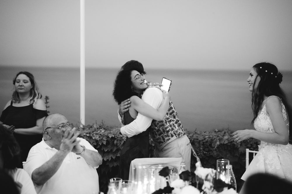 Guests embrace emotionally during the wedding reception at Villa Casa Rossa in Imperia.