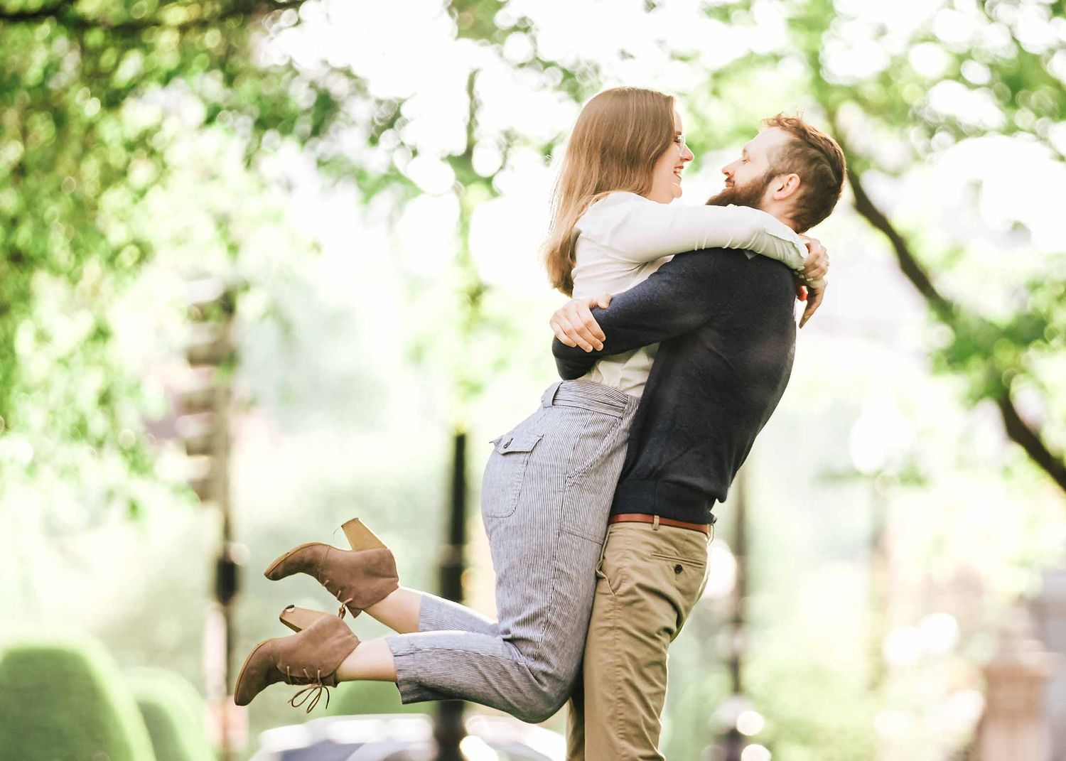 Romantic close-up of couple embracing with dreamy backlight in tree-lined Commonwealth Avenue Mall during Boston engagement session