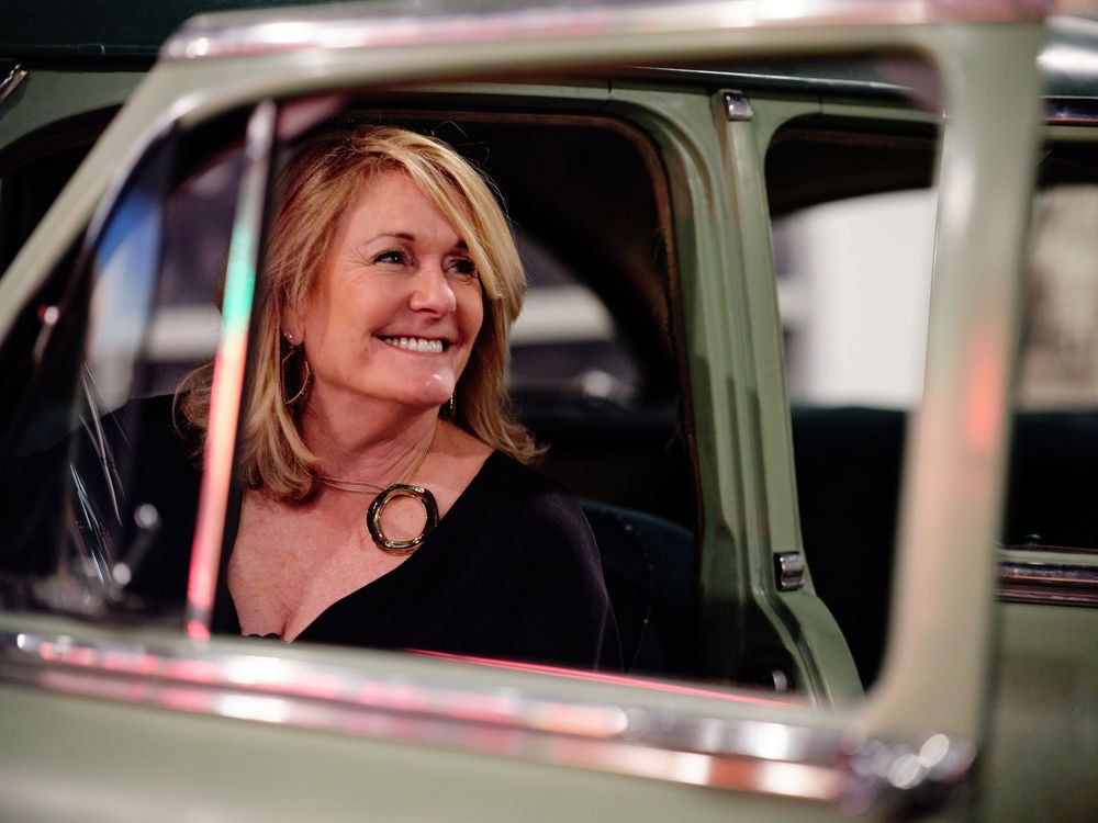 Creative portrait of woman framing face through vintage car window at Baltimore Museum of Industry.