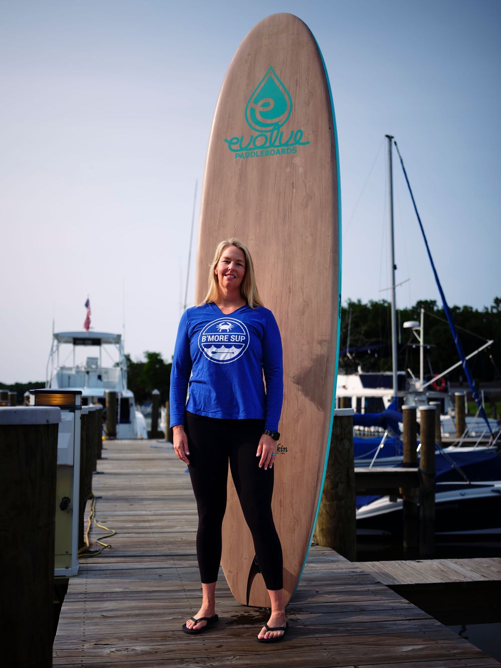 Lifestyle branding portrait of B'more SUP owner with paddleboard on the Patapsco River.