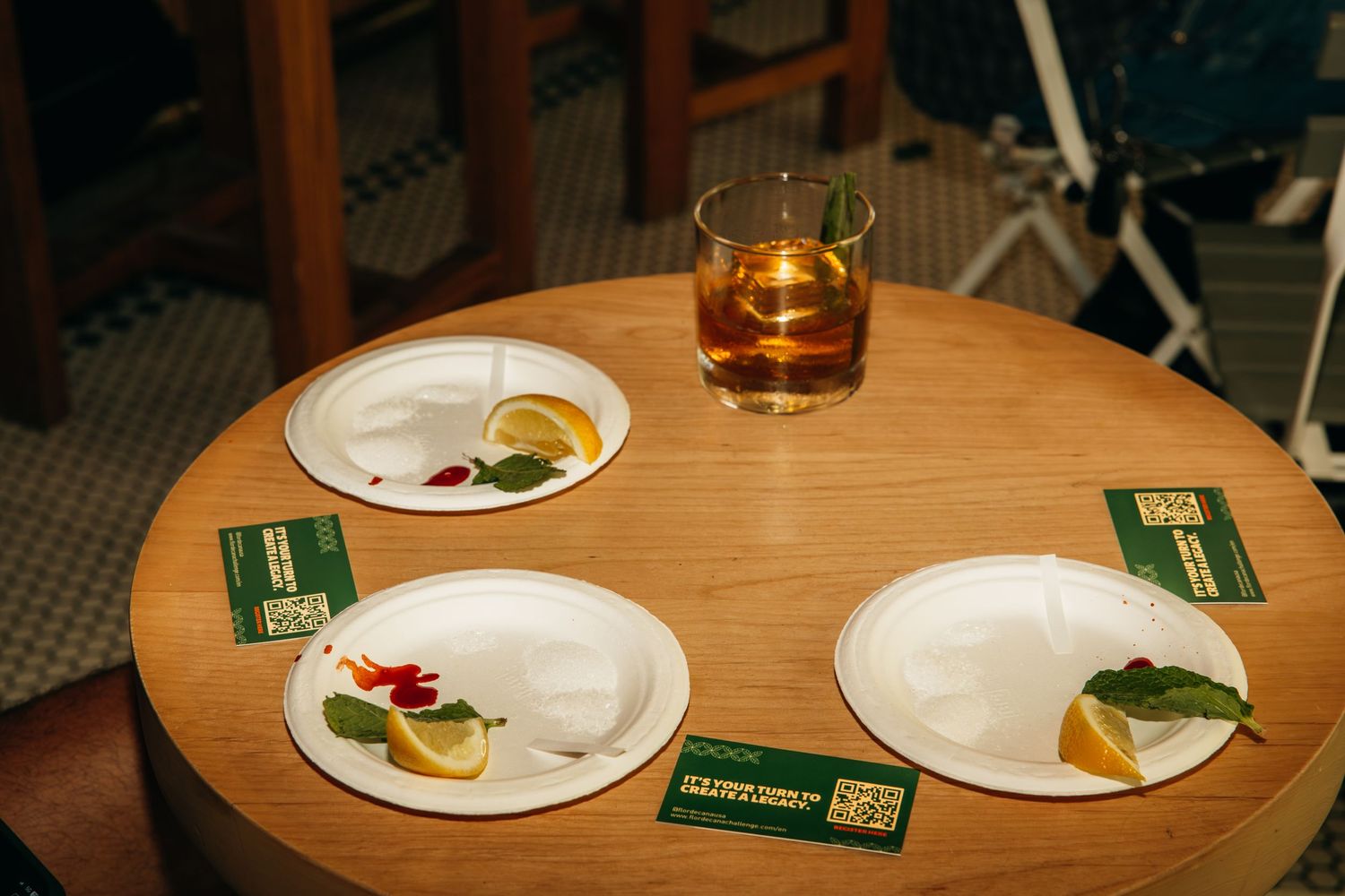 Place settings and drinks arranged on round wooden table at restaurant.