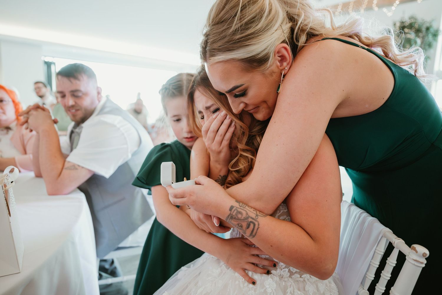 Wedding party shares emotional embraces and candid moments at an elegant celebration.