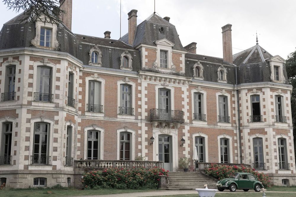 Château élégant en briques et pierres blanches avec une voiture vintage, idéal pour un mariage chic à Montauban – Laetitia KLOPOCKI