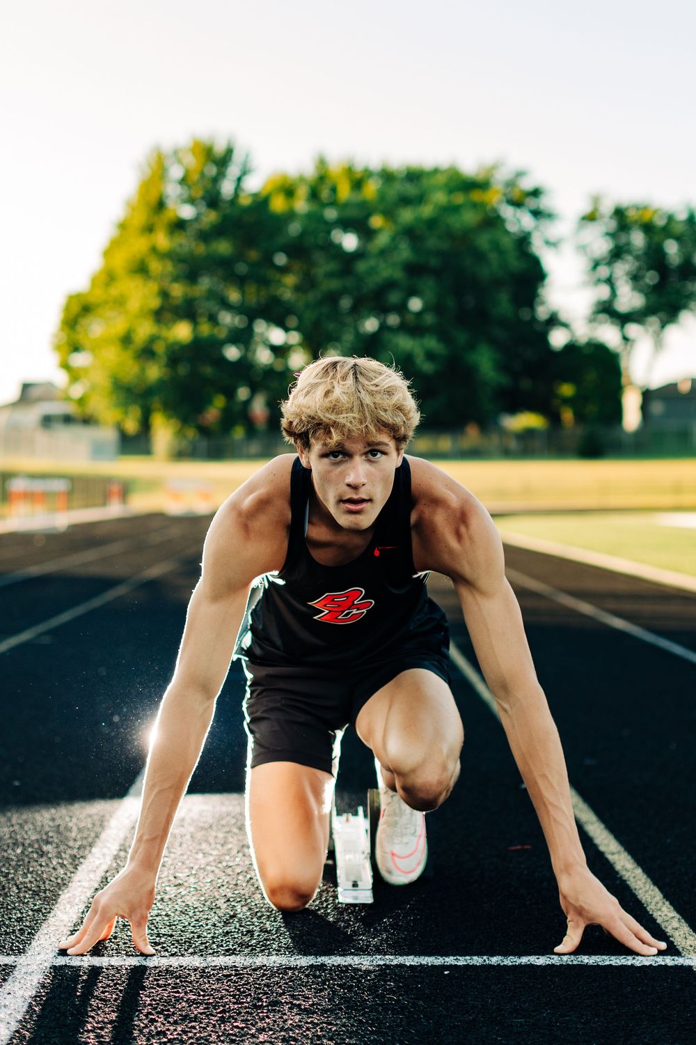Runner in starting position on track ready for race start.