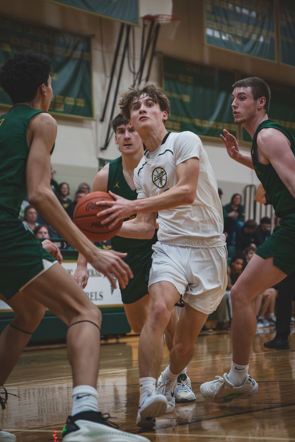 Sports Photography of a basketball player driving through defenders during competitive high school game - Monroe, Michigan