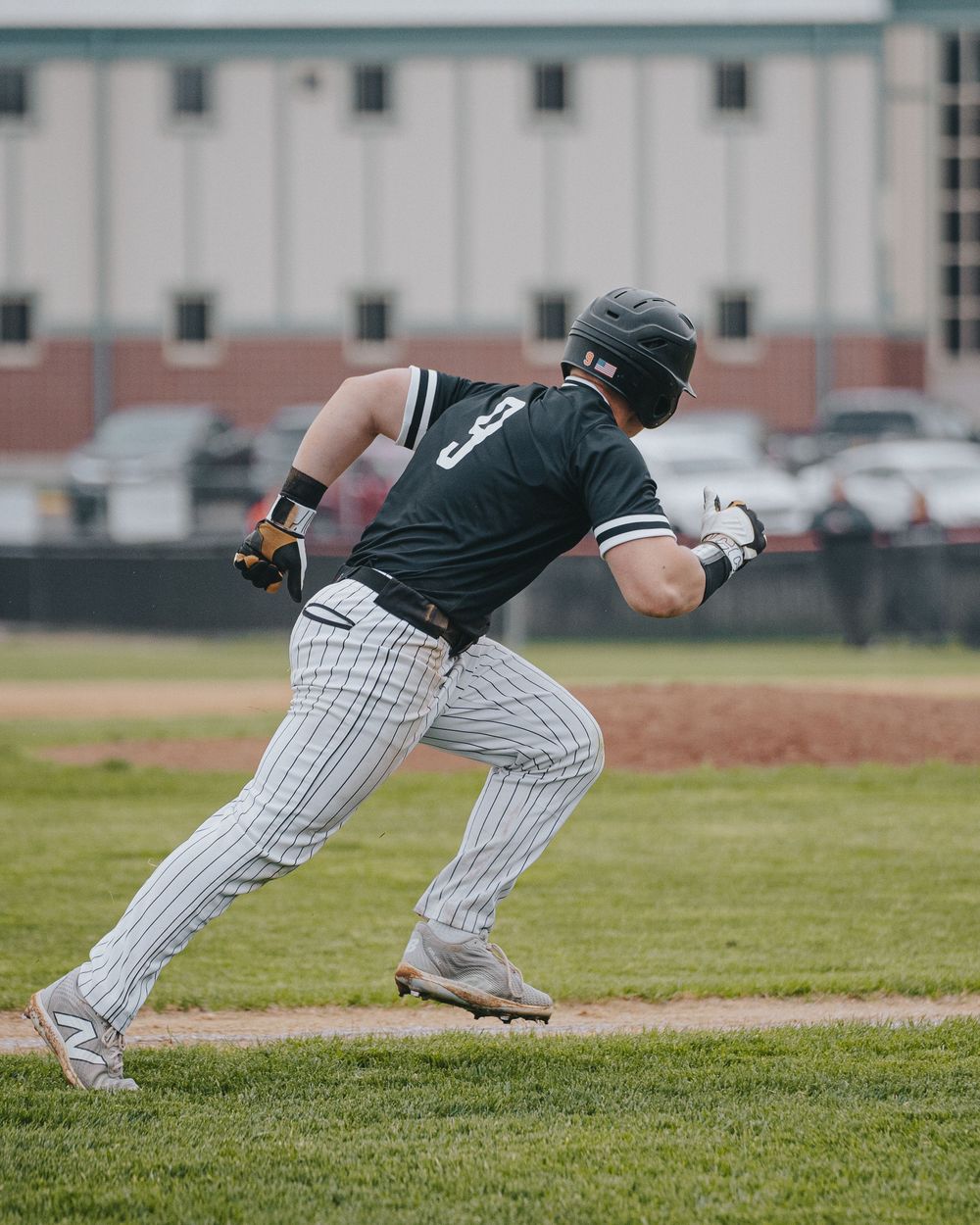 Sports Photography of Baseball player in pinstripe uniform running off first base during game  - Warsaw, Indiana