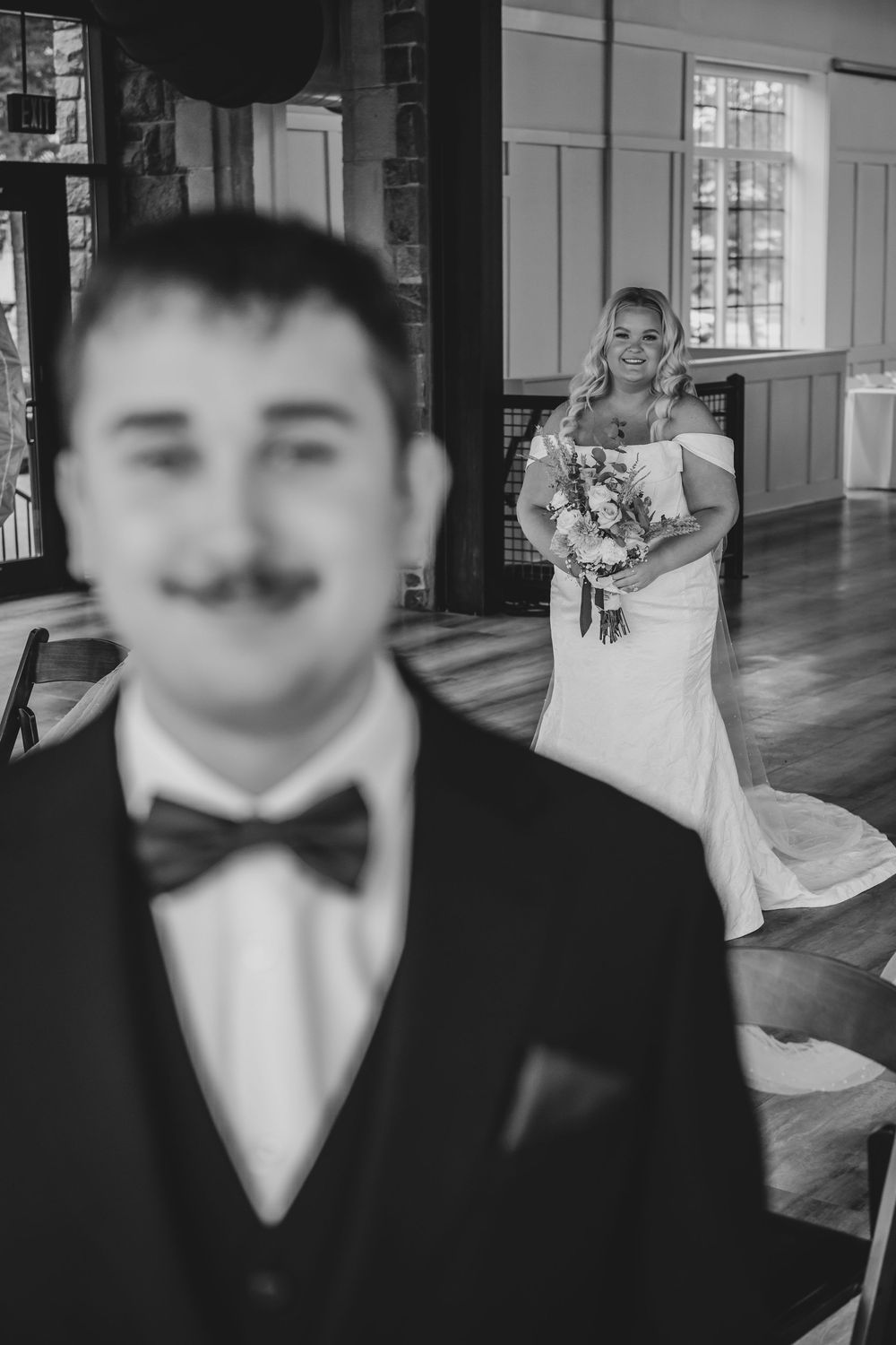 A series of black and white wedding photos showing a couple in formal attire dancing and posing in an elegant venue.