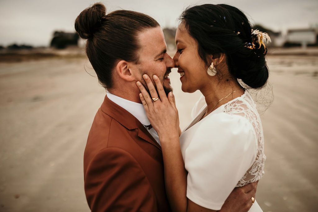 Tender romantic moment between newlyweds in desert setting with rustic elegance.