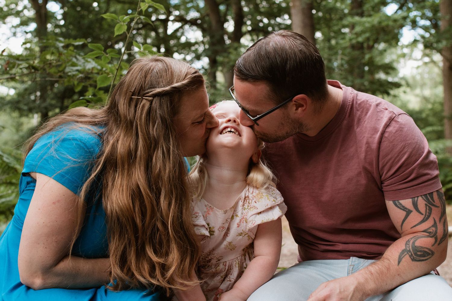 Intimate family moment captured on a wooded trail during golden hour.