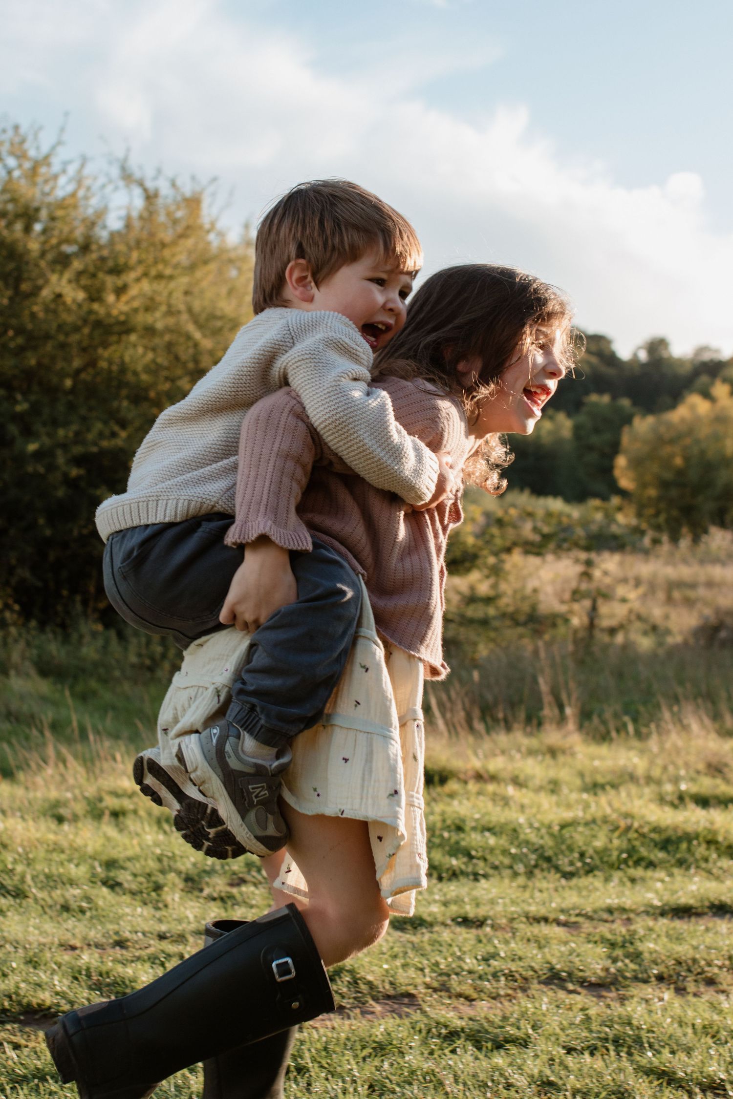 Playful piggyback ride captured in a sunlit meadow during golden hour.