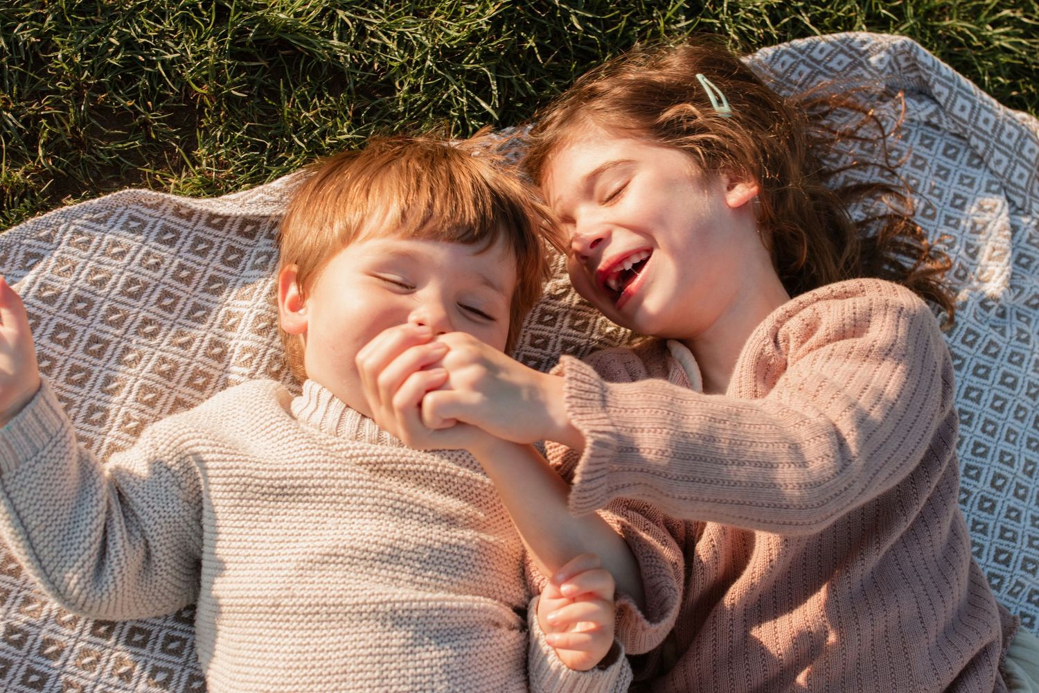 Sweet moments shared on a cozy blanket outdoors during a sunny afternoon.