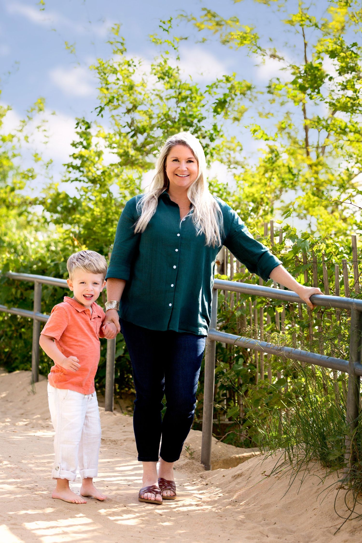 Mom posing with toddler at rocky gap beach in benton harbor michigan on a summer day on lake michigan