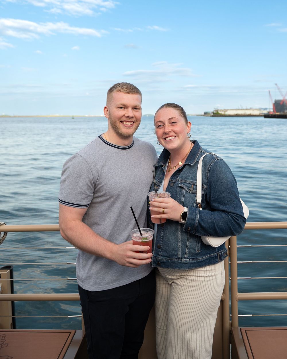 A couple enjoying a scenic boat ride on the water during a sunny day.