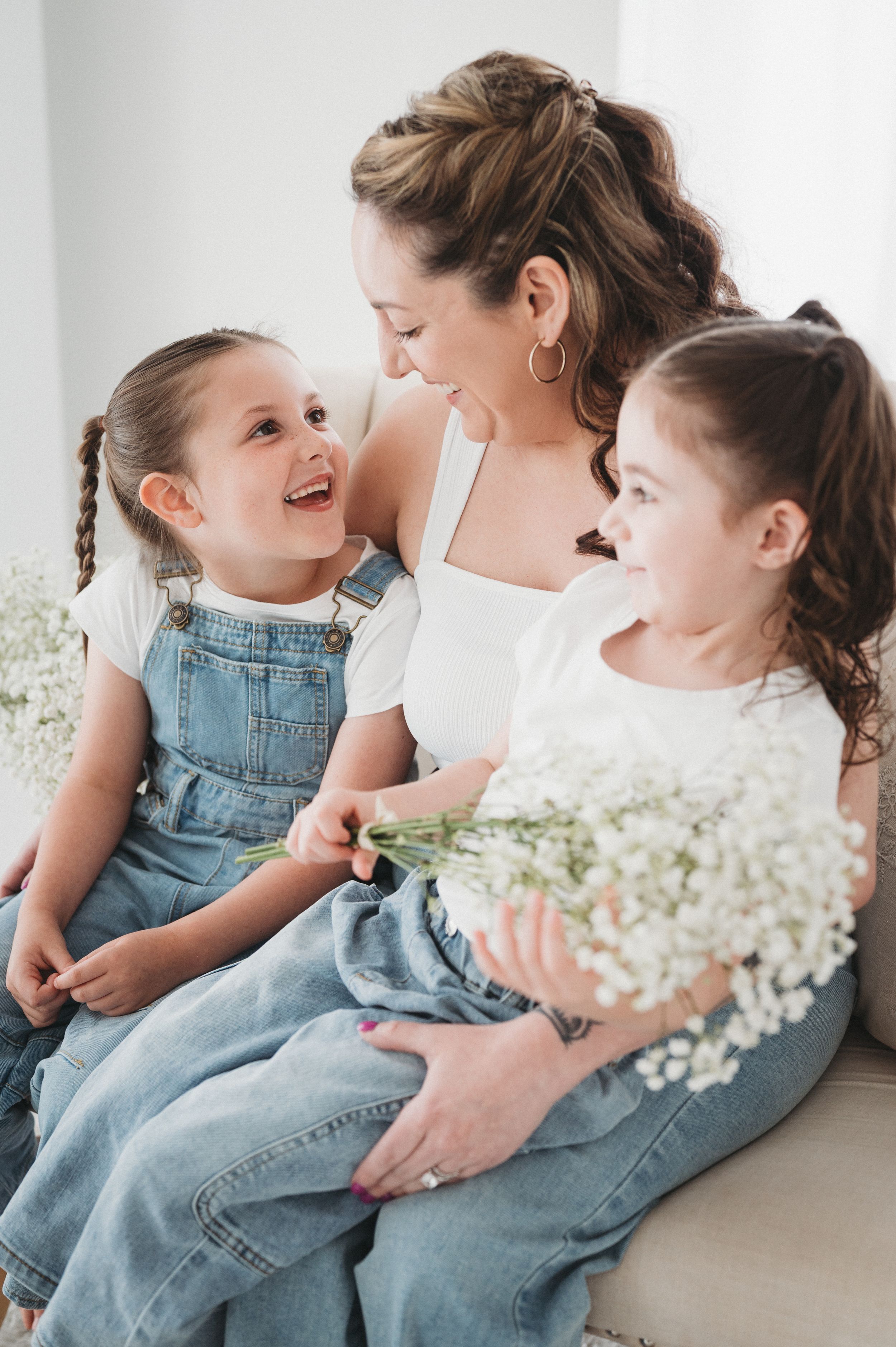 Mother and child in denim sharing joyful moments with white flowers.