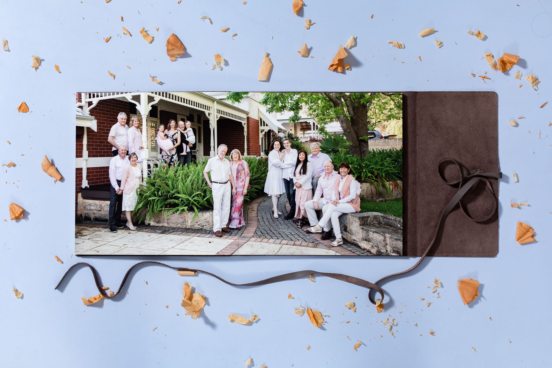 A photo album page with a wedding party gathered outside a venue, decorated with orange autumn leaf accents.