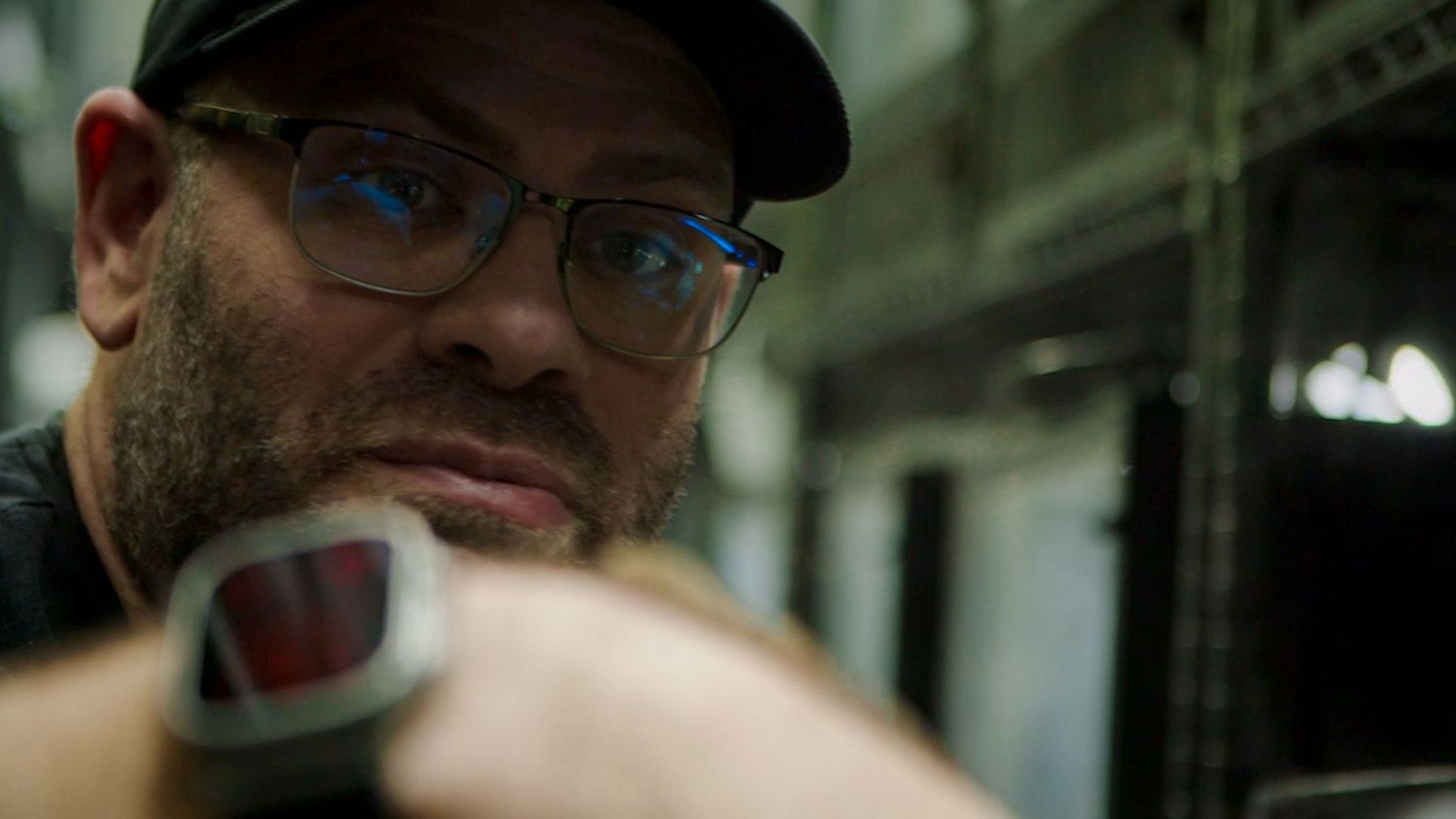 A close-up view of someone wearing glasses in an office setting.