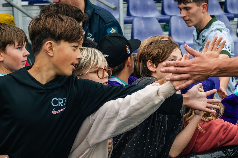A group of people in a crowd looking at something off camera during an event.