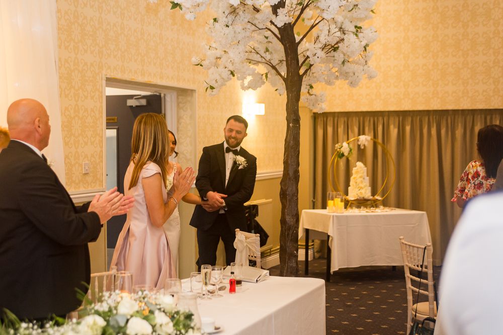 Wedding reception guests mingling and celebrating at decorated banquet tables.