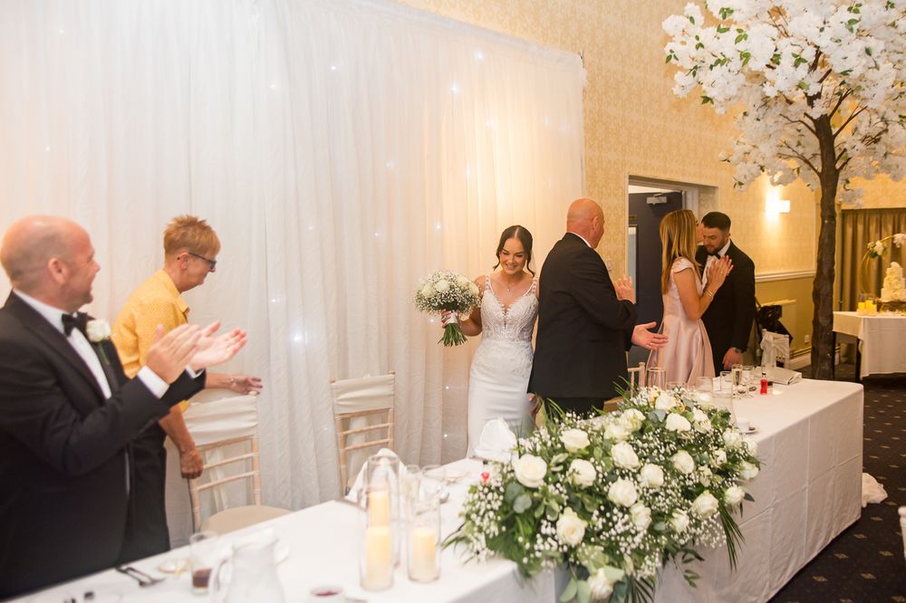 Wedding reception guests applauding during celebrations in an elegant banquet room.