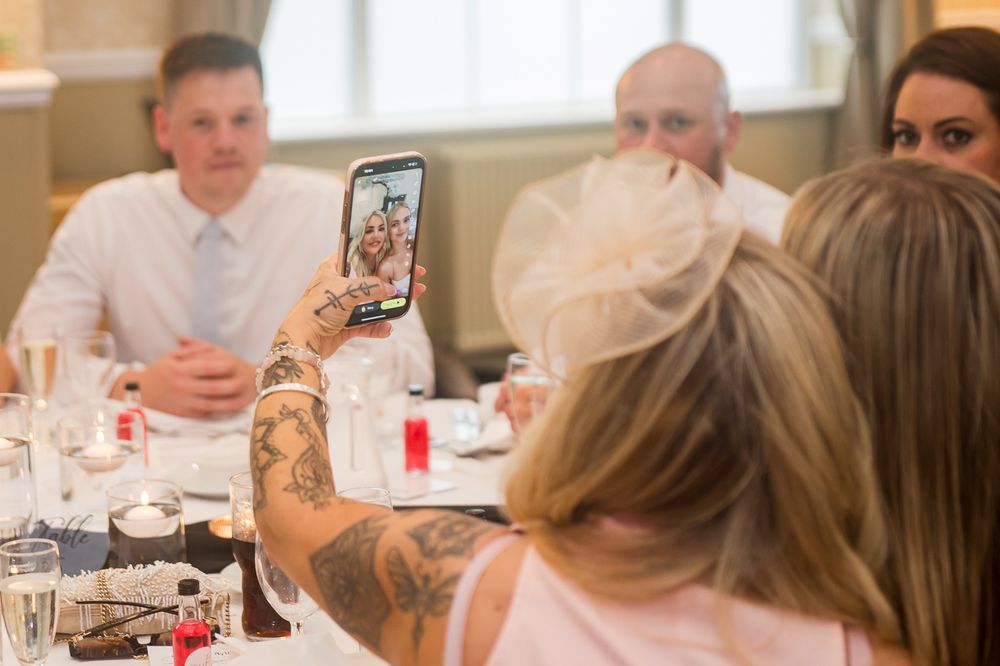 Wedding guests engaged in conversation during formal reception dinner.